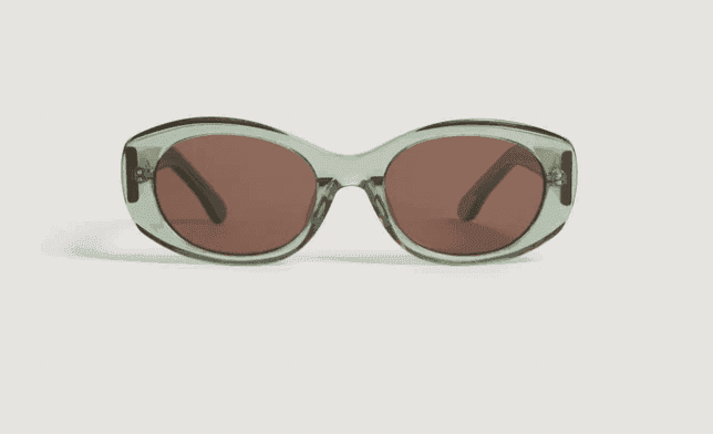 Une paire de lunettes de soleil avec des montures translucides vert clair et des verres marron, vues de face sur fond blanc.