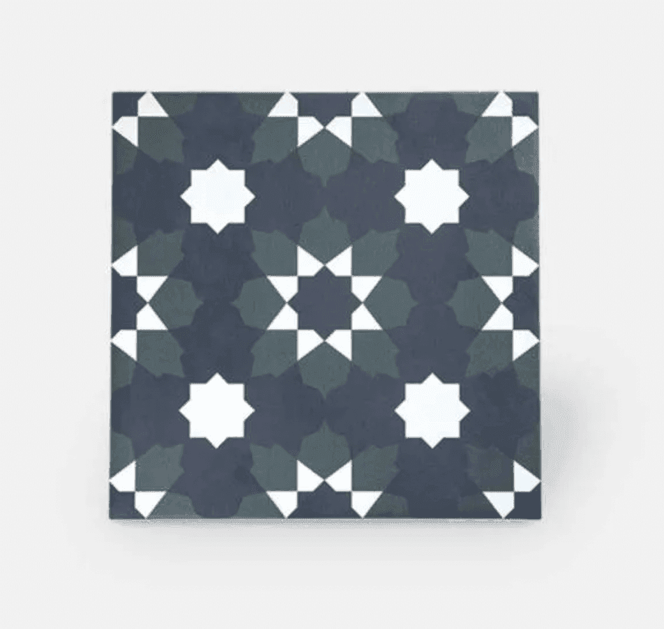Un carreau carré au motif géométrique présente des étoiles blanches à huit branches sur un fond gris foncé. Les étoiles sont reliées par des formes sombres superposées, formant un motif symétrique.