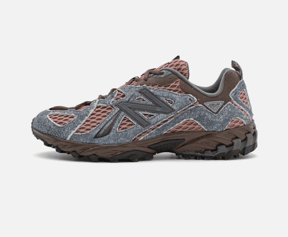 Vue de profil d'une sneaker associant mesh gris et marron et daim. La chaussure est dotée d'une semelle en caoutchouc texturé et du logo de la marque sur le côté, avec un design complexe et des tons naturels.