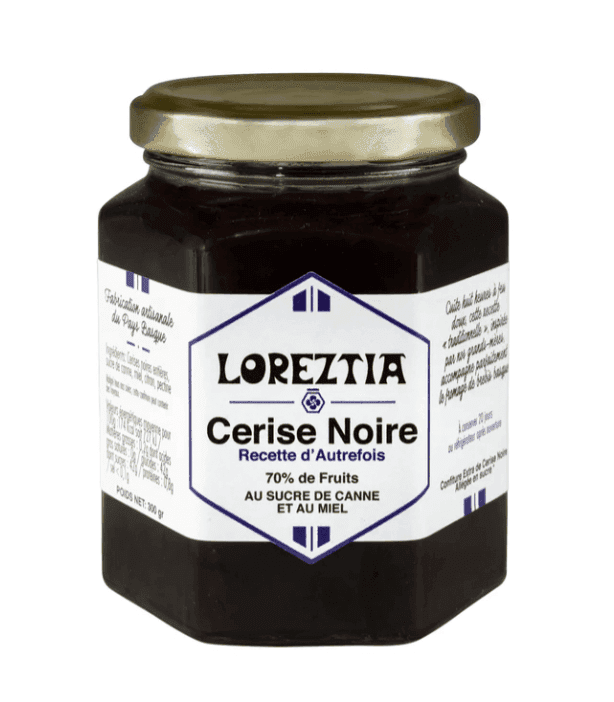 Pot de confiture Loreztia Cerise Noire. L'étiquette, en français, mentionne « Recette d'Autrefois » avec 70 % de fruits, du sucre de canne et du miel. Il est doté d'un couvercle en métal et d'un verre hexagonal, contenant de la confiture de cerises noires.