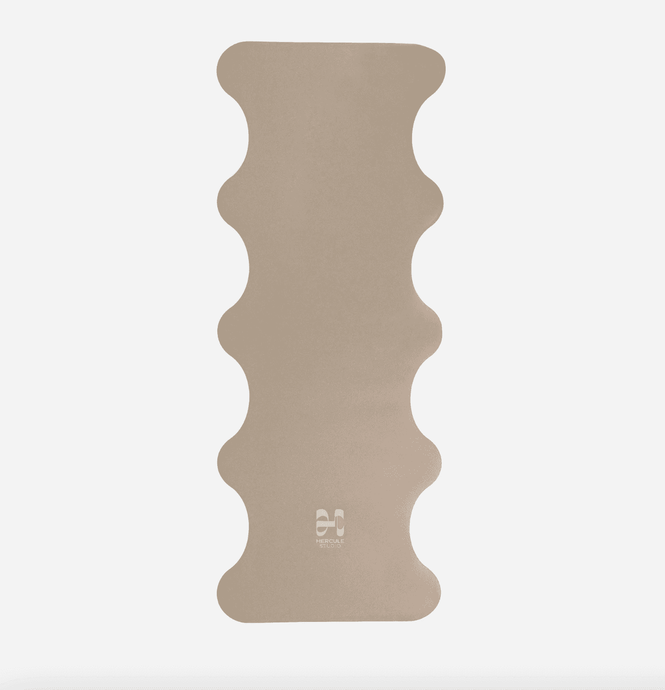 Un tapis de yoga beige aux bords ondulés des deux côtés, posé à plat sur un fond blanc. Le dessous du tapis arbore un petit logo composé de deux cercles superposés.