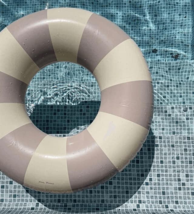 Bouée à rayures mauves et blanches dans une piscine