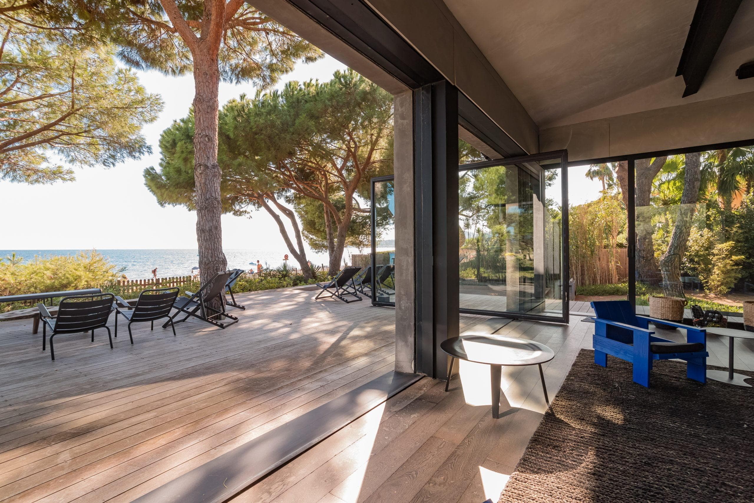 salon ensoleillé par l'ouverture des grandes baies vitrées de la villa