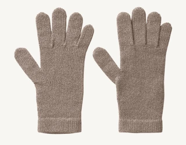 Une paire de gants tricotés beiges est présentée sur un fond blanc uni. Les gants sont placés côte à côte avec les doigts étendus, révélant leur matière texturée.