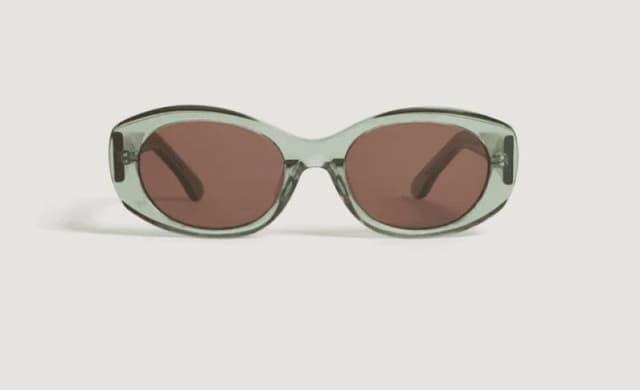 Une paire de lunettes de soleil avec des montures translucides vert clair et des verres marron, vues de face sur fond blanc.
