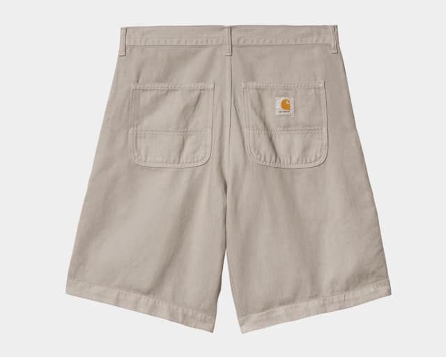 Short de travail beige avec deux grandes poches arrière, dont une ornée d'un petit patch logo marron. Ce short est plat, mettant en valeur sa coupe droite et son tissu résistant.