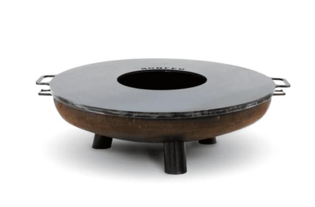 Un brasero d'extérieur rond et rustique, doté de trois pieds courts et d'un large anneau métallique plat autour d'un centre ouvert. Des poignées sont présentes de chaque côté de l'anneau, et l'inscription « BONFEU » est visible sur le dessus.