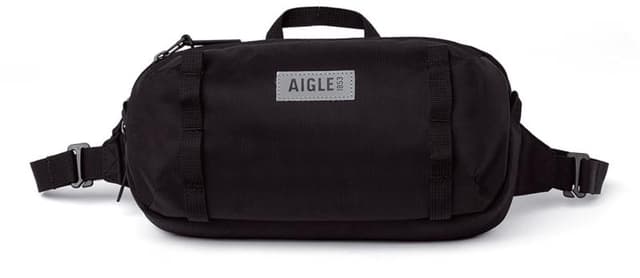 Black rectangular waist bag with adjustable straps and a carry handle on top. The front features a gray patch labeled "AIGLE" in bold letters.