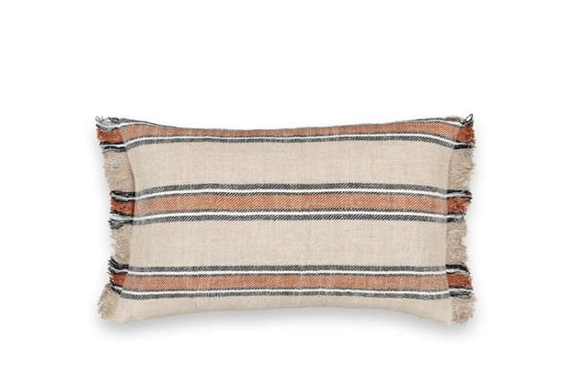 Un coussin rectangulaire avec un tissu beige, des rayures horizontales noires et orange et des bords effilochés sur tous les côtés, affiché sur un fond blanc.