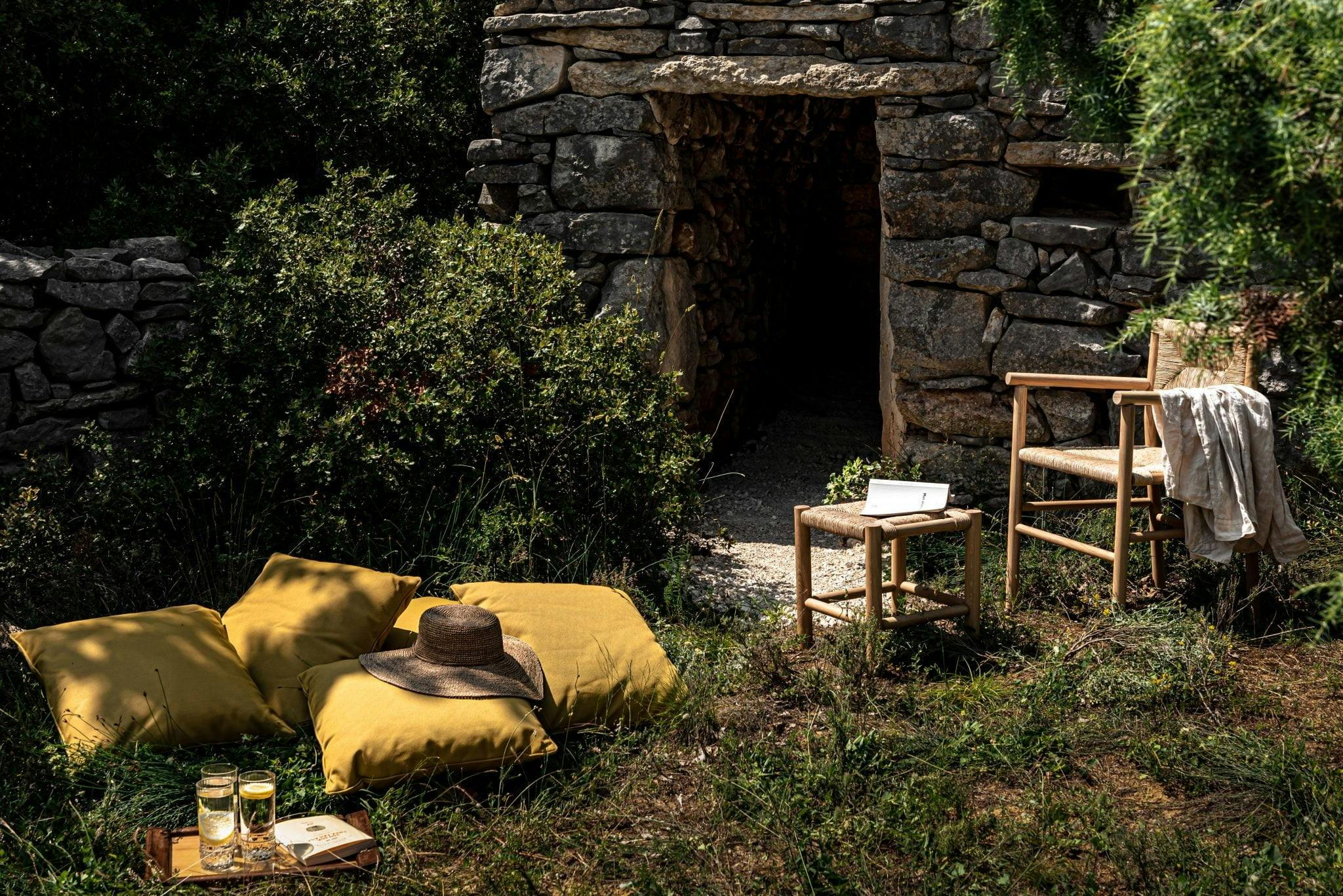 Jardin aménagé en coin lecture avec des coussins et des chaises