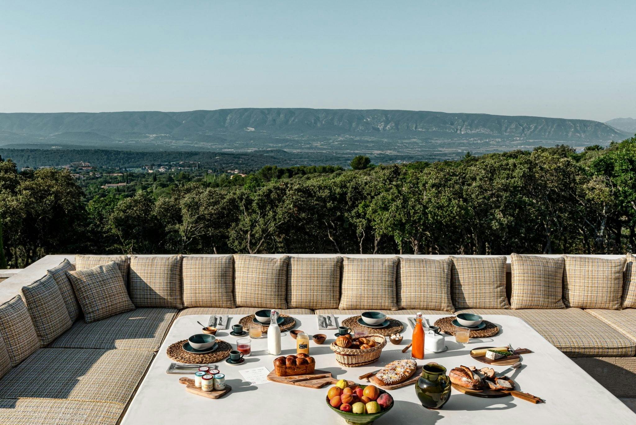 Vue imprenable sur la banquette nature provençale et la table de petit déjeuner aux Hauts de Gordes