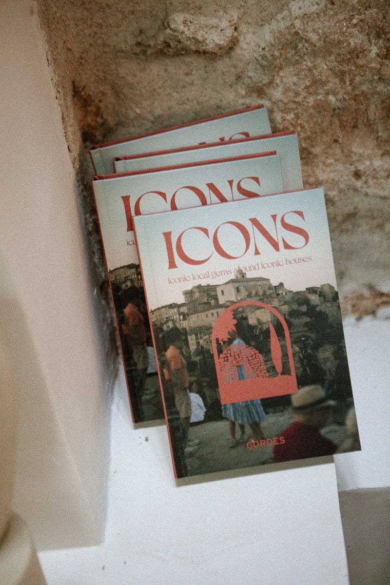 3 livres Icons, guides papier sur le village de Gordes, adossés à un mur en pierre