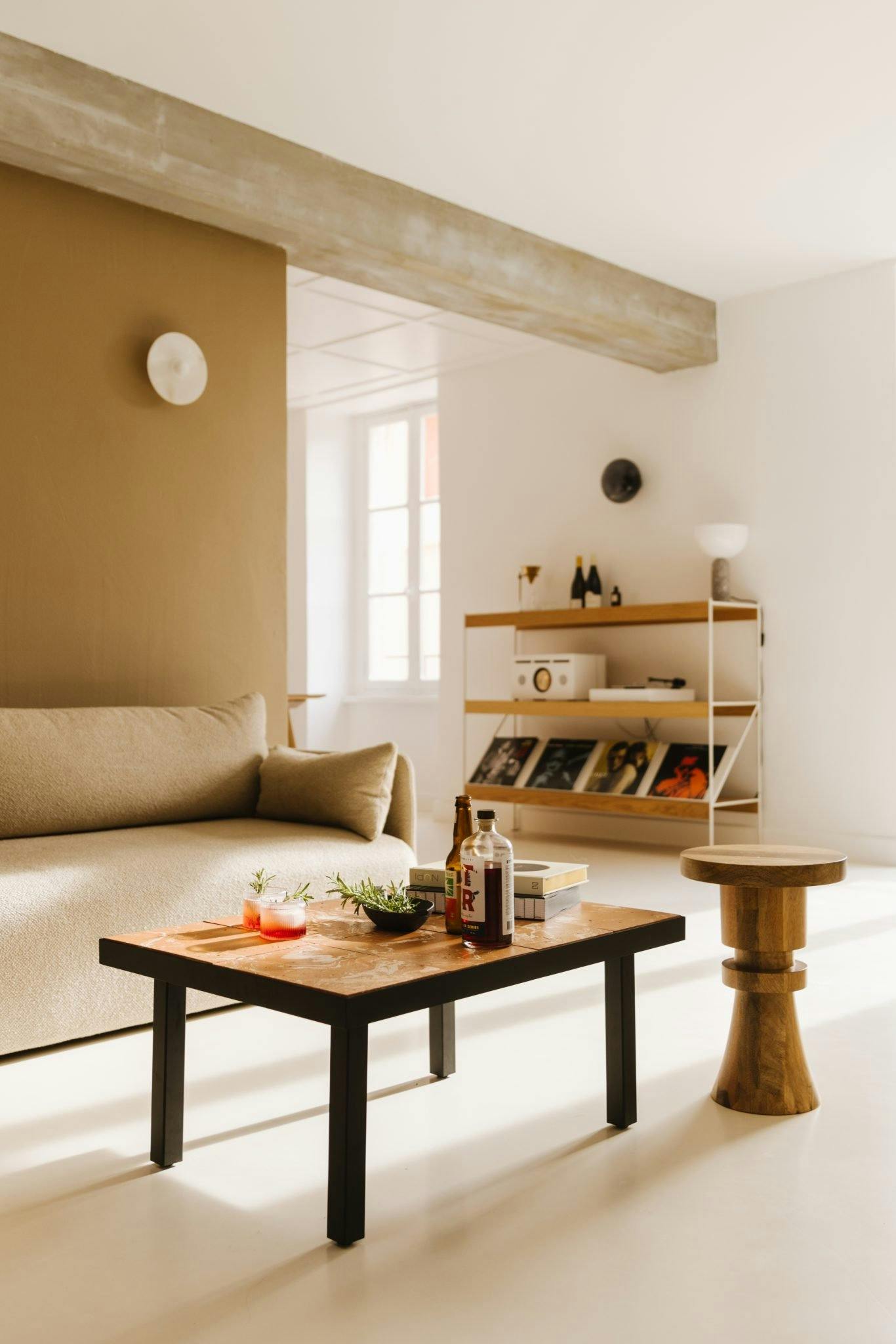 salon avec canapé et table basse en bois, étagère en arrière plan décorée