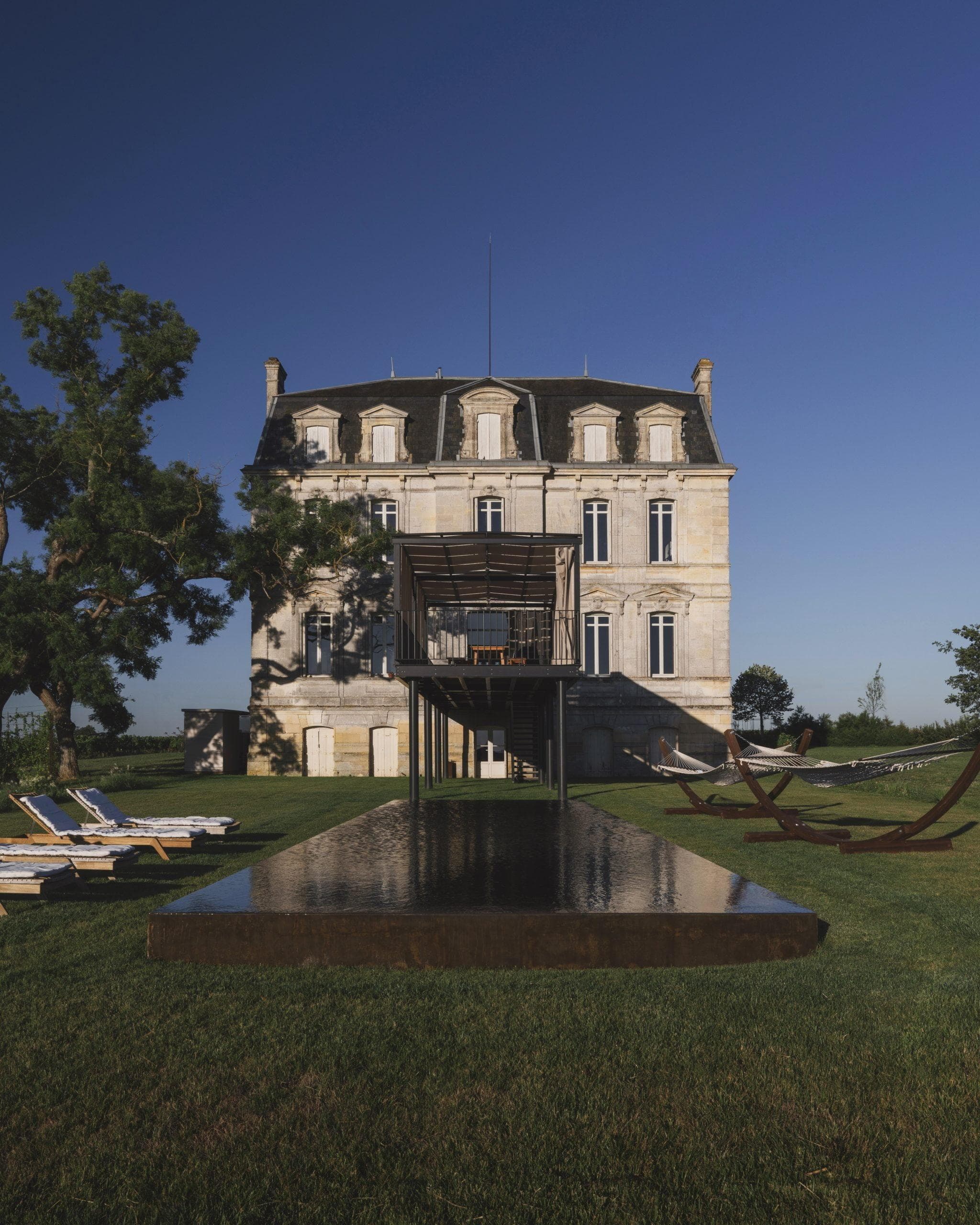 Vue sur le château, la piscine et le jardin