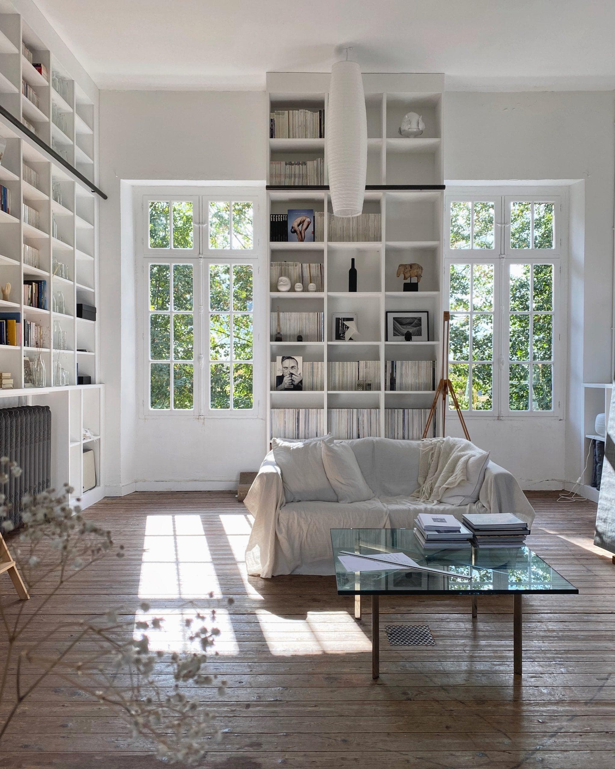 On the first floor, a living area with a wall-mounted bookshelf.