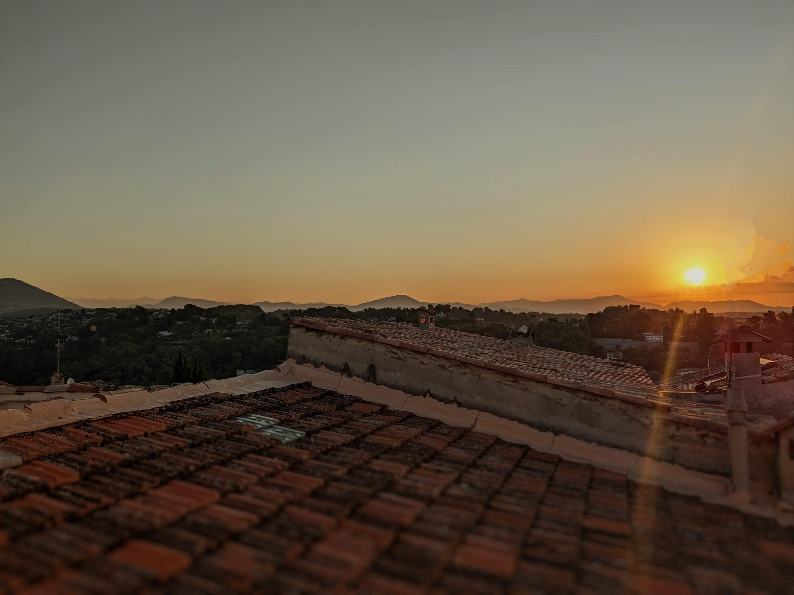Vue sur les toits du village et au loin les montagnes.