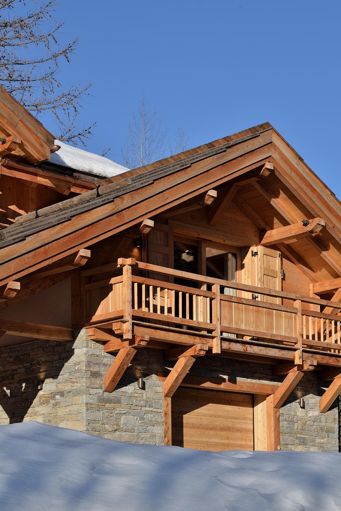 A solid wooden chalet, nestled facing the mountains, with just a hint of snow on the roof: the raw elegance of the Alps. © Erick-Saillet
