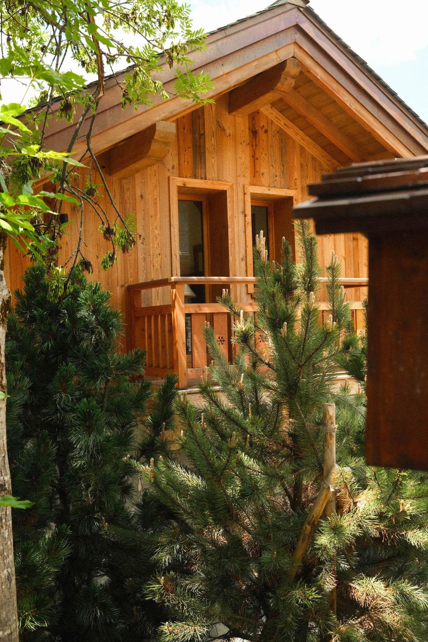 The chalet appears among the fir trees.