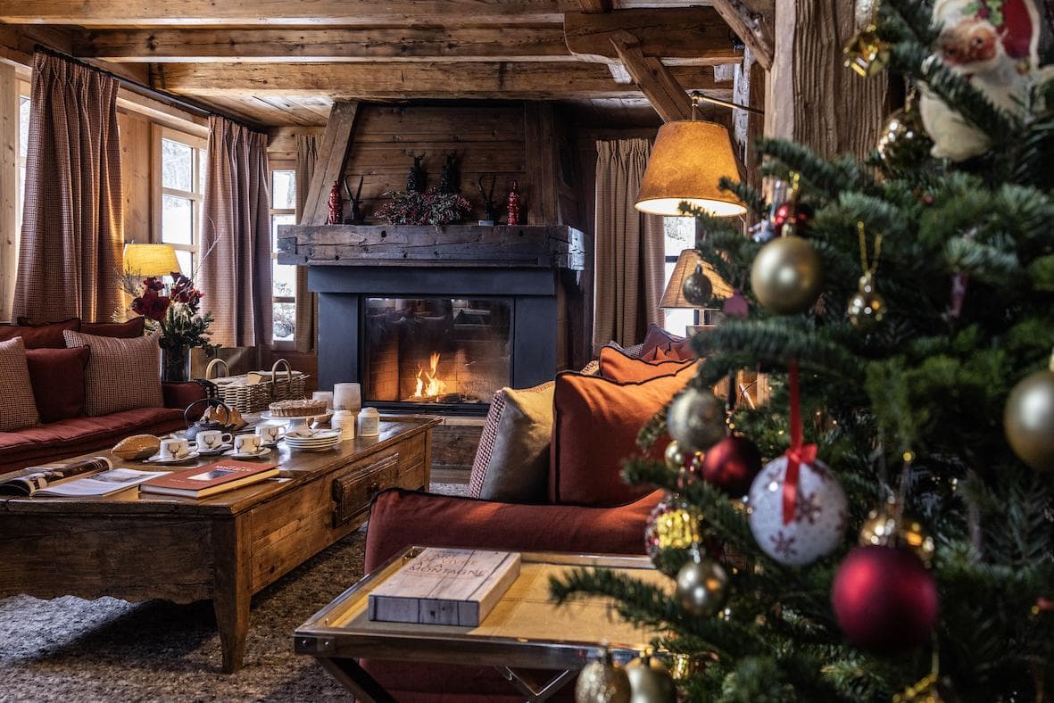Living room of Chalet Châtel in Megève, featuring a fireplace and a decorated Christmas tree.