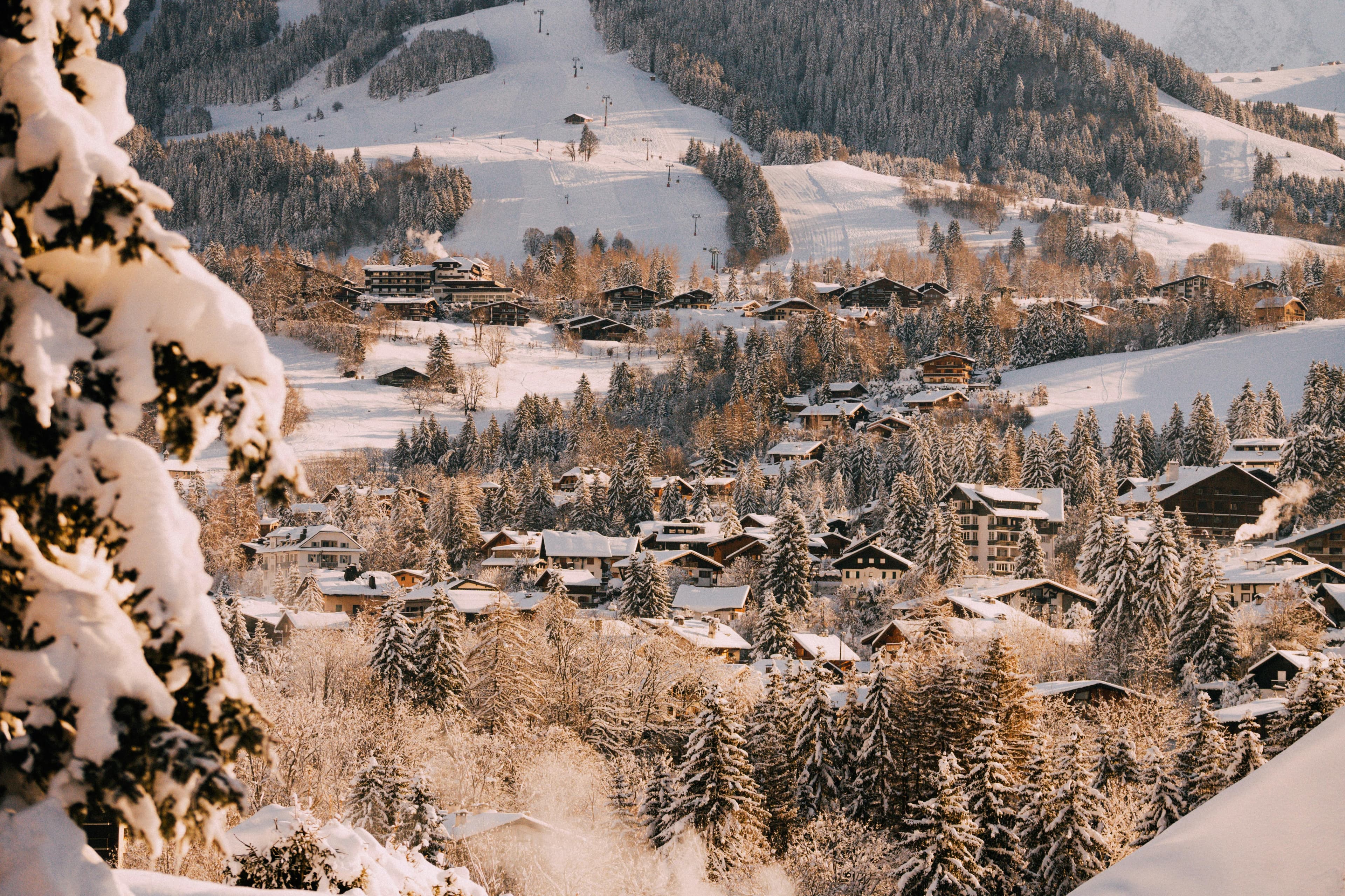 Snow-covered panorama of Megève, with its rooftops dusted in white and elegant chalets nestled at the foot of the Alps. © Mathurin Napoly